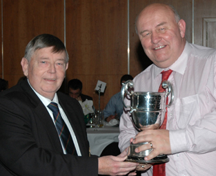 NCU President Ian Gourley presents Muckamore stalwart Ivan McCombe with the Midweek League Trophy